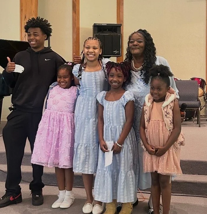 Young people and an adult smiling together in the sanctuary at Easter.